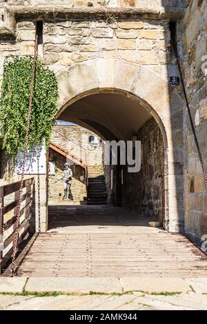 Eingangsbrücke des Museums des castello di san Giusto mit Tunnel und Zugbrücke. Im Hintergrund steht eine Statue Stockfoto