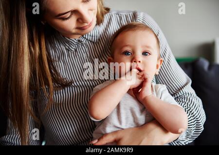 Junge Mutter, die ihr kleines Mädchen umarmt Stockfoto