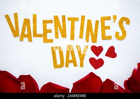 Happy Valentines Day Grußkarte mit roten Rosenblättern und weißem Holzhintergrund, romantisch und Love Concept Stockfoto