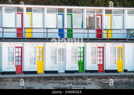 Eine Reihe von bunt und hell lackiert Chalet Türen in Primärfarben, Porthgwidden Strand, St Ives, Cornwall, England, Großbritannien Stockfoto