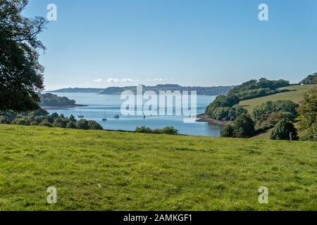 Blick auf die Mündung des Flusses Fal durch Bäume aus der Nähe von Trelissick an einem sonnigen Sommertag im September mit blauem Himmel, Cornwall, England, Großbritannien Stockfoto