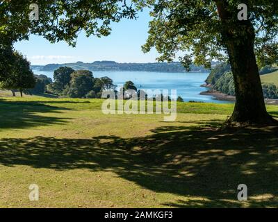 Blick auf die Mündung des Flusses Fal durch Bäume aus der Nähe von Trelissick an einem sonnigen Sommertag im September mit blauem Himmel, Cornwall, England, Großbritannien Stockfoto