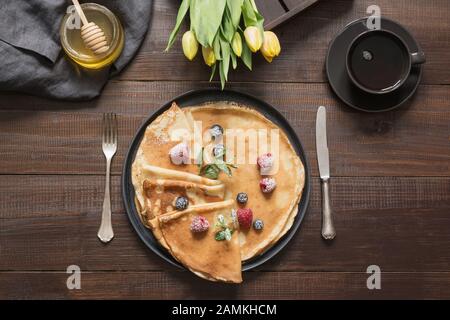 Leckere traditionelle russische Frühstückspancakes, Kaffee, Honig auf Holztisch. Draufsicht. Traditionelle Bedienung. Pfannkuchenwoche. Shrovetide Stockfoto