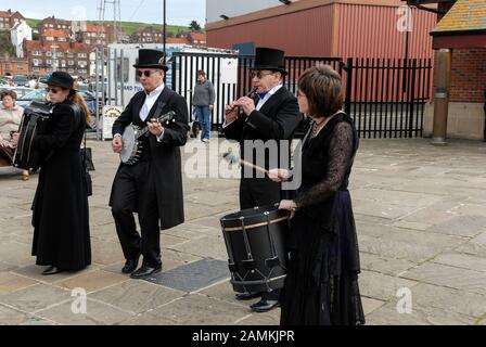 Morris Dancing in Whitby, North Yorkshire, Großbritannien die Jet Set Border Morris Dancers benannt nach dem berühmten Whitby Jet Black Edelstein, tragen einen Stockfoto