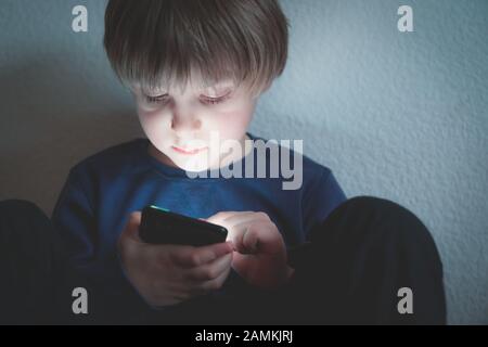 Cyber-Mobbing-Konzept - depressiver Junge mit Telefon und negativen Kommentaren Stockfoto