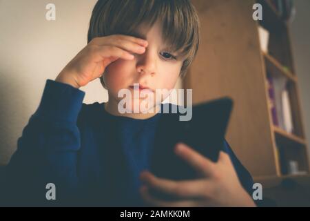 Cyber-Mobbing-Konzept - depressiver Junge mit Telefon und negativen Kommentaren Stockfoto