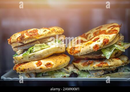 Huhn, Salat und sonnengetrocknete Tomaten Focaccia Sandwiches zum Verkauf in einem Café in der Flughafenlounge Stockfoto