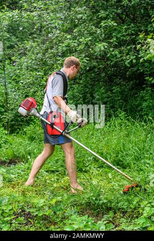 Gärtner mäht das Unkraut in meinem Garten Stockfoto