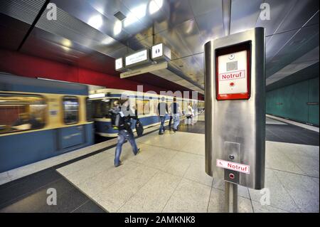 Notrufstelle im U-Bahnhof Wettersteinplatz, im Hintergrund eine abfahrende U-Bahn. [Automatisierte Übersetzung] Stockfoto