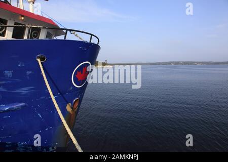 Schiff mit kanadischer Flagge am Bug im Hafen von Sambro, Nova Scotia, Kanada, Nordamerika. [Automatisierte Übersetzung] Stockfoto