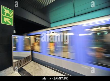 Eine abfahrende U-Bahn spiegelt sich im Sicherheitsspiegel am Bahnsteigende am U-Bahnhof Wettersteinplatz wider. [Automatisierte Übersetzung] Stockfoto