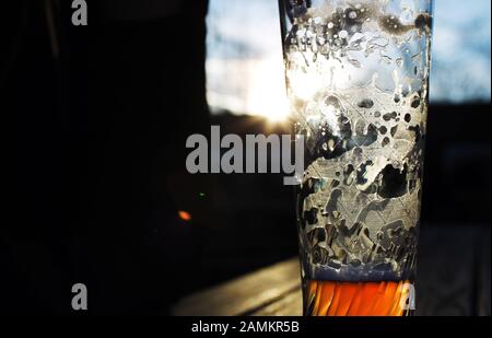 Halb leeres Weizenbierglas vor dem Kloster Fürstenfeld. [Automatisierte Übersetzung] Stockfoto