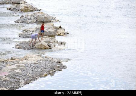 Zwei Mädchen an der Isar in der Münchner Innenstadt. [Automatisierte Übersetzung] Stockfoto