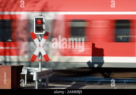 Eine S-Bahn passiert den geschlossenen Bahnübergang im Hebelwerk in Emmering. [Automatisierte Übersetzung] Stockfoto