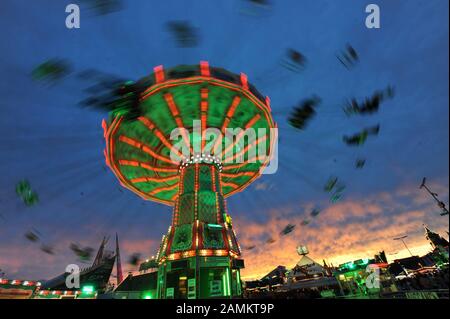 Oktoberfest 2012: Farbenfroh beleuchtetes Kettenkarussell mit Abendhimmel auf dem Münchner Oktoberfest. [Automatisierte Übersetzung] Stockfoto