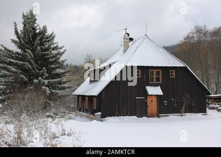 Typisches Holzhaus im Winter in der Nähe des Grenzdorfes Zelezna Ruda/Bayerisch Eisenstein, Nationalpark Sumava, Böhmerwald, Tschechien, Europa [automatisierte Übersetzung] Stockfoto