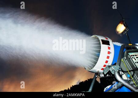 Schneekanone in der Dämmerung auf der Bergstation Hochbrixen oberhalb von Brixen im Thale in Österreich im Einsatz. [Automatisierte Übersetzung] Stockfoto