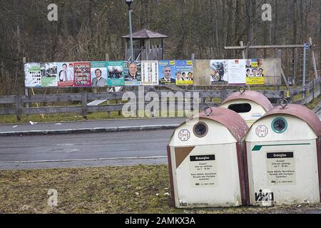 Holztafeln mit Wahlplakaten am Zaun eines Kinderspielplatzes in Miesbach. Die Plakate mit dem von der Affäre gebeutelten Miesbacher Landrat Jakob Kreidl (CSU) wurden weggenommen. Im Vordergrund Flaschenbank. [Automatisierte Übersetzung] Stockfoto