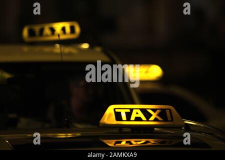 Taxis in München warten auf Kunden mit beleuchteten Schildern. [Automatisierte Übersetzung] Stockfoto