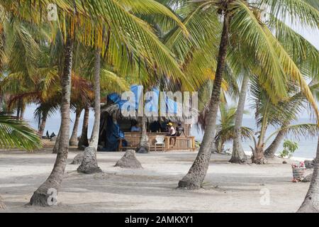 Bar der Kuna-Indianer unter Kokospalmen am Strand der San Blas-Inseln, Panama, Mittelamerika. [Automatisierte Übersetzung] Stockfoto