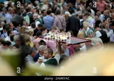 Ein Kellner trägt ein Tablett Essen durch das gut gefüllte "Ochsenbratereizelt" beim Münchner Oktoberfest. [Automatisierte Übersetzung] Stockfoto