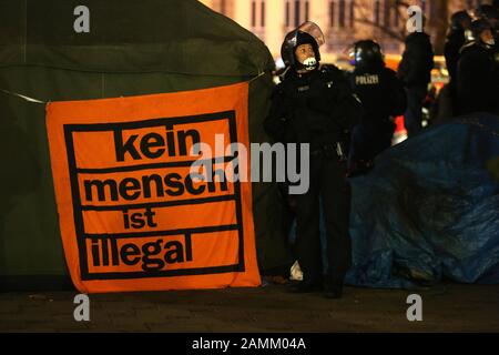 Polizeibeamte räumen in der Münchner Innenstadt ein Lager von hungernden Asylbewerbern. Im Vordergrund steht der Slogan "niemand ist illegal". Etwa 30 Asylbewerber aus ganz Bayern campen seit 5 Jahren vor der Matthäuskirche am Sendlinger-Tor-Platz und protestieren mit einem Hungerstreik gegen die Residenzpflicht und ein Bleiberecht in Deutschland. [Automatisierte Übersetzung] Stockfoto