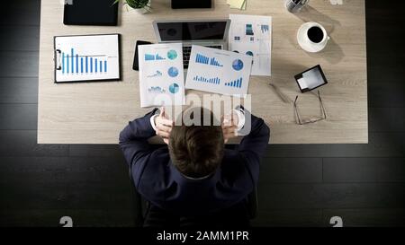Müde Geschäftsleute sitzen am Tisch im Büro, denken an Projekt, Draufsicht Stockfoto