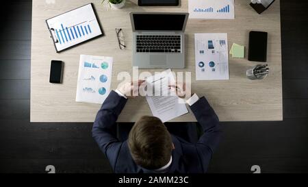 Man liest Geschäftsvertrag, schließt Vertrag mit Partner ab, Draufsicht Stockfoto
