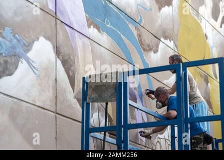 Graffiti-Künstler schmücken mit ihrer Sprühkunst die Außenwand der neuen Flüchtlingswerkstatt in der Asylbewerberunterkunft in der ehemaligen bayerischen Kaserne an der Heidemannstraße 60. Stockfoto