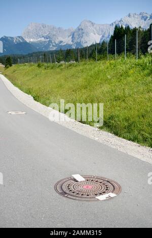 Themenwanderung unter dem Motto "Das ist der Gipfel" rund um den G7-Gipfel 2015 in Elmau. Die Wanderung führt von Ferchensee nach Schloss Elmau durch die Alpenwelt des Karwedel. Das Bild zeigt eine versiegelte Mannlochabdeckung. [Automatisierte Übersetzung] Stockfoto