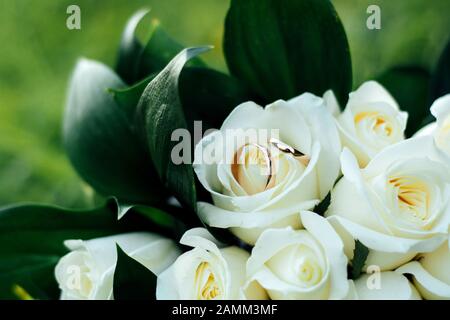 Wunderschönes Hochzeits-Bouquet und ein Ring, der auf dem Gras liegt Stockfoto