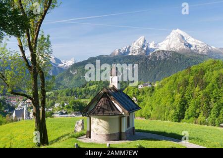 Die Kirchleitner Kapelle am Mitterweinfeld hoch über Berchtesgaden mit dem mächtigen Watzmann im Hintergrund im üppig grünen Frühsommer, Berchtesgadener Land [automatisierte Übersetzung] Stockfoto