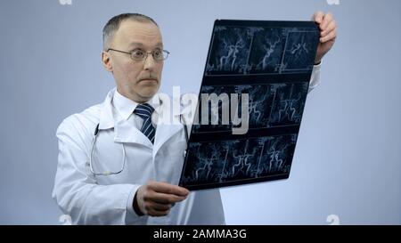 Erfahrener Kardiologe, der den CT-Scan von Blutgefäßen überprüft hat, sieht überrascht aus Stockfoto