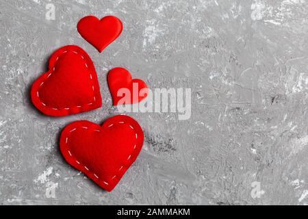 Draufsicht Zusammensetzung der roten Herzen auf Zementhintergrund. Romantisches Beziehungskonzept. Valentinstag. Stockfoto