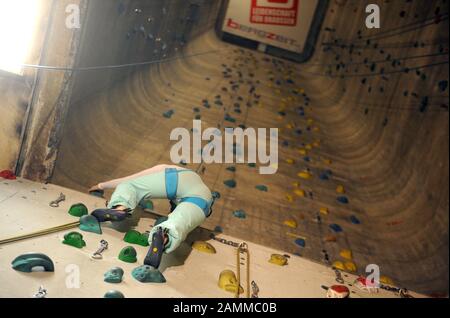 Frau klettert in der Kletterhalle "Himmelstor" auf dem alten Pfanni-Areal am Ostbahnhof. [Automatisierte Übersetzung] Stockfoto