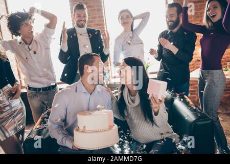 Foto der Gruppe Freunde, die die Überraschung Baby Party Hochzeit Jahrestag zukünftige Eltern sitzen Sofa halten großen Kuchen küssen Konfetti fallen Verschleiß formalwear Stockfoto