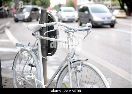 An der Ecke Rosenheimer und Balanstraße erinnert ein weiß lackiertes Geisterrad an einen Radfahrer, der Opfer eines tödlichen Unfalls wurde, als sie von der plötzlich endenden Radfahrbahn auf die Straße wechseln musste. [Automatisierte Übersetzung] Stockfoto