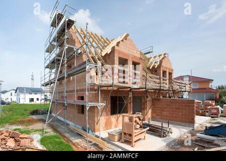 Hausbau in Schale mit Backsteinen und Dachstuhl [automatisierte Übersetzung] Stockfoto