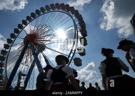 Trachtler vor dem Riesenrad an der Münchner Wiesn. [Automatisierte Übersetzung] Stockfoto