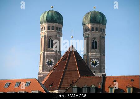 Die charakteristischen Zwillingstürme des Münchner Liebfrauendoms zeigen zwei verschiedene Male. Da im Südturm noch Sanierungsarbeiten durchgeführt werden, zeigt die Uhr im Südturm immer zwölf Uhr, während ihr Gegenstück im Nordturm bereits korrekt läuft. [Automatisierte Übersetzung] Stockfoto