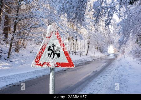 Warnschild für rutschigen Schnee auf der Landstraße [automatisierte Übersetzung] Stockfoto