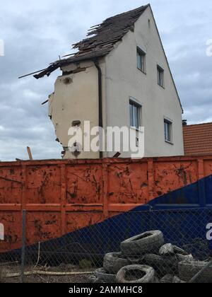 Das Abbruchhaus im Münchner Stadtteil Hadern ist jetzt nur noch zur Hälfte fertig. Die Ruine scheint sich im Abbruchbehälter zu befinden. [Automatisierte Übersetzung] Stockfoto