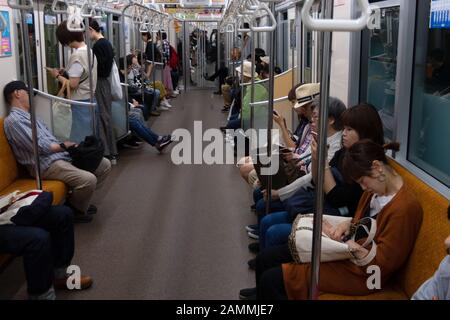 Japanische Menschen pendeln mit der U-Bahn in Sapporo, Hokkaido, Japan, Asien. Passagiere, die in der U-Bahn sitzen Stockfoto