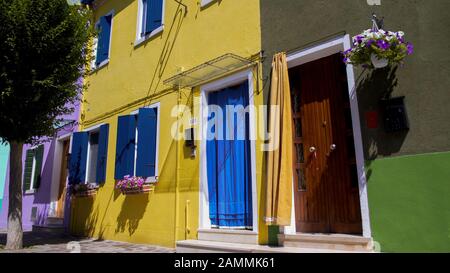 Gepflegte, gepflegte Häuser in leuchtenden, lebendigen Farben mit Blumen dekoriert Stockfoto