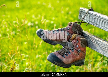 Wanderstiefel hängen beim ruhen auf Holzbank [automatisierte Übersetzung] Stockfoto