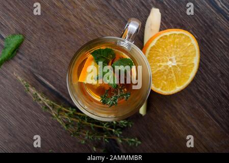 Draufsicht. Nahaufnahme. Glasbecher mit Vitamintee. Zutaten für Vitamintee auf einem Holztisch. Vorbeugung gegen Erkältungen. Gesunder Lebensstil. Stockfoto