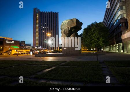 Das Karl-Marx-Denkmal ist eine Skulptur, die den Kopf von Karl Marx stilisiert darstellt. Sie ist das Wahrzeichen der Stadt Chemnitzer und liegt in der Innenstadt an der Brückenstraße nahe der Kreuzung mit der Straße der Nationen. Im Hintergrund steht das Mercure Hotel [Automated Translation] Stockfoto