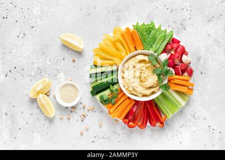 Hummus mit frischem Gemüse, gesundem vegetarisches Speisekonzept, Draufsicht Stockfoto