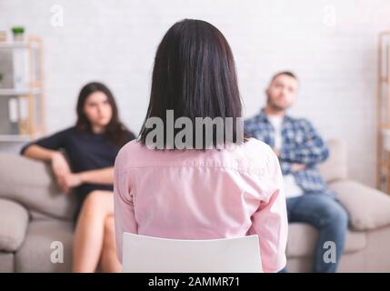 Der Berater hört auf, wie Mann und Frau Probleme teilen Stockfoto