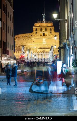 Rom, Italien. Castel Sant'Angelo und seine Brücke bei Nacht mit Massen von Menschen auf den Straßen Stockfoto